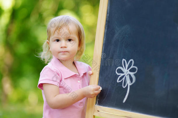 可爱的幼儿用粉笔画画