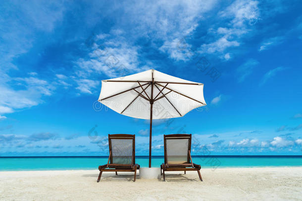 沙滩上的沙滩躺椅和雨伞。休息、放松、度假、水疗、度假的概念。