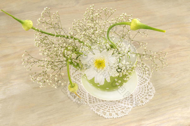 一束白色的花，放在绿色的波尔卡圆点杯里，作为母亲节