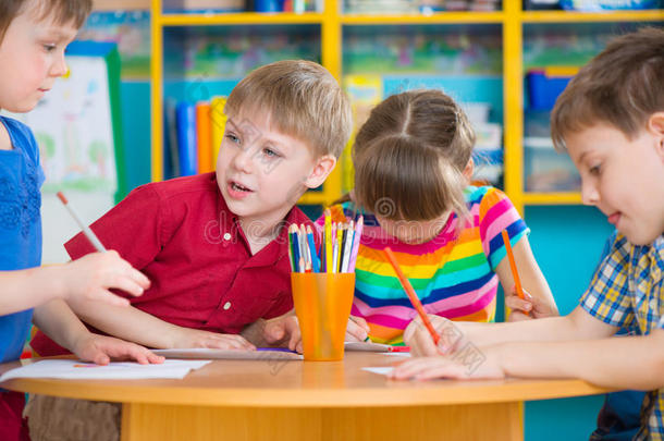 幼儿园里可爱的小朋友用五颜六色的颜料画画