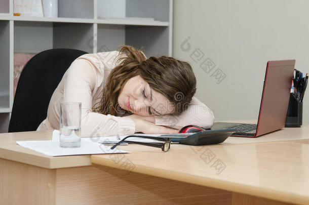 女孩在他办公室的笔记本电脑前睡着了