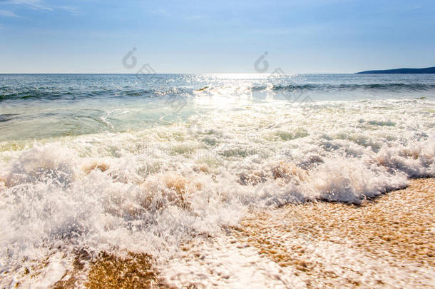 日出后的沙滩和蓝天，海水飞溅