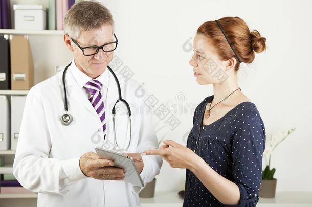 医生和一位女病人在平板电脑上展示一些东西