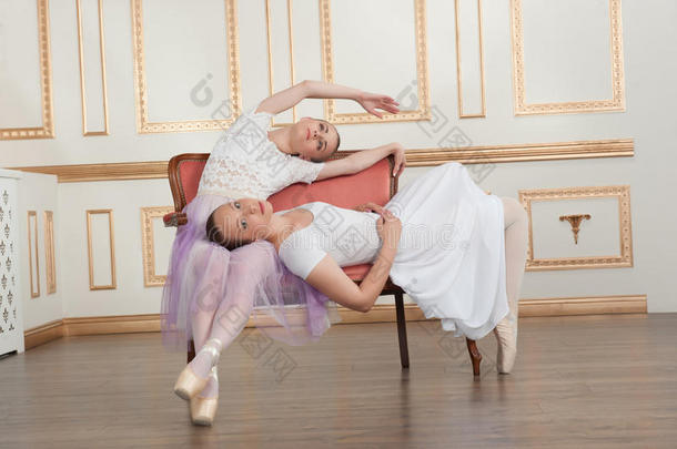 两个年轻漂亮的芭蕾舞演员<strong>坐在沙发</strong>上