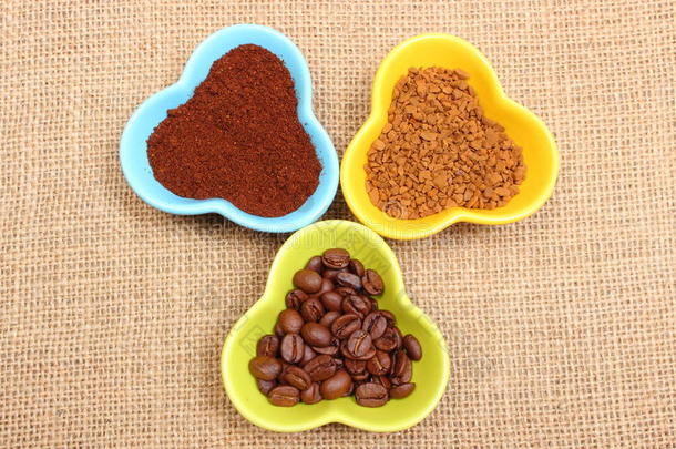 五颜六色杯子里的谷物，磨碎的咖啡和速溶咖啡