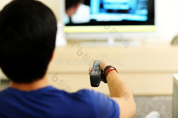 一个男人在家看电视的画像