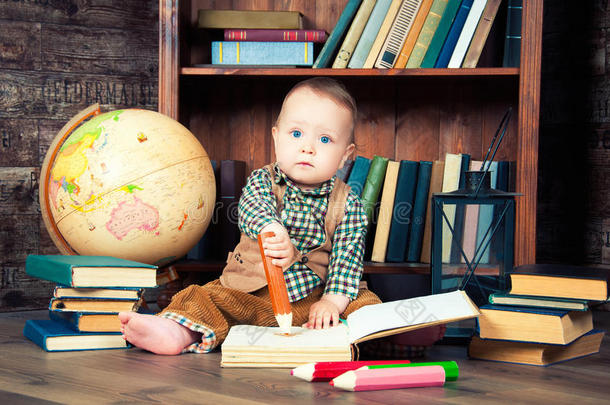 可爱的小男孩坐在地球仪，<strong>书</strong>和<strong>画笔</strong>