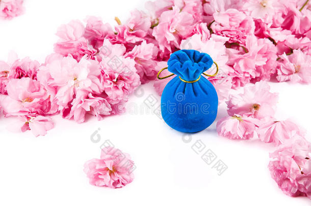 蓝色天鹅绒首饰礼盒，四周是粉色樱桃花