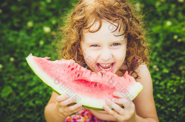 快乐的小女孩在夏日公园吃西瓜。instagram过滤器。