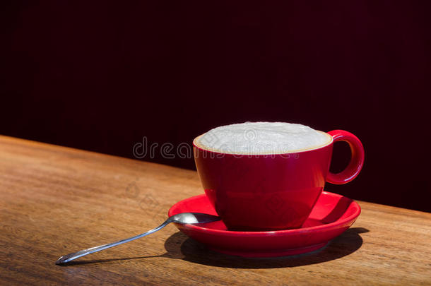 酒吧里有一个带勺子的红色咖啡杯