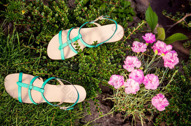 绿凉鞋躺在草地上，女士们穿着舒适的鞋子