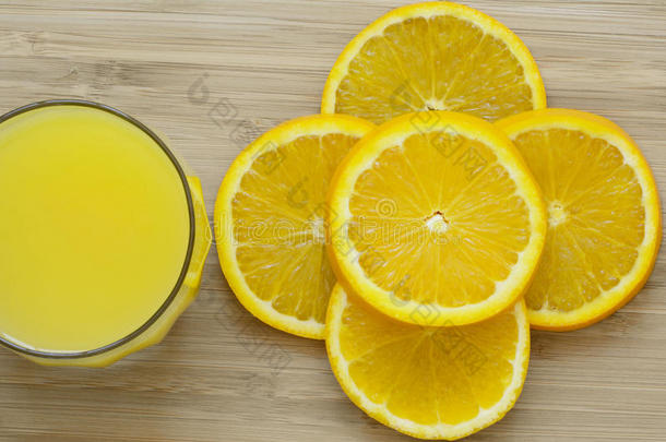 切碎的橙子和一整杯橙汁<strong>放在木质</strong>表面的特写镜头