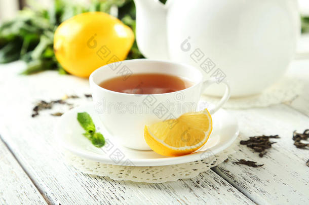 白色木质背景茶杯和茶壶中的绿茶