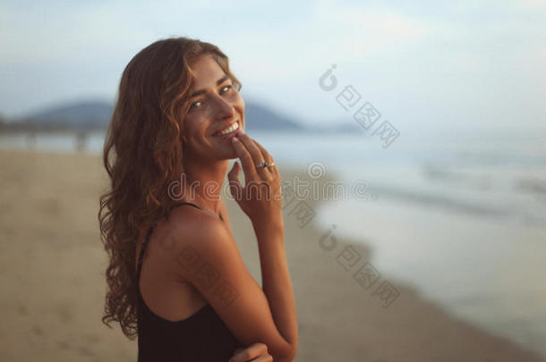 海边一位年轻的卷发美女的画像