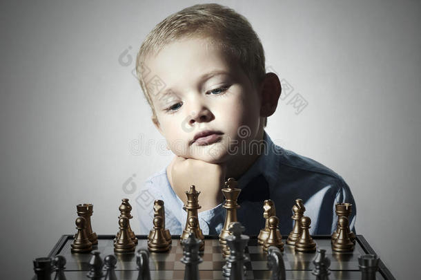 小男孩在玩象棋。聪明孩子。小天才孩子。聪明的游戏棋盘