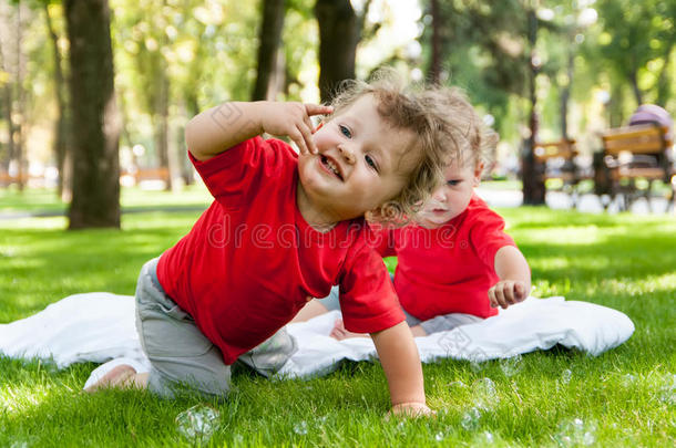 孩子们双胞胎在草地上玩耍