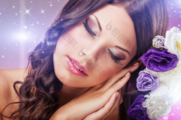 美丽的梦中女人闭着眼睛，在紫色的花朵旁边