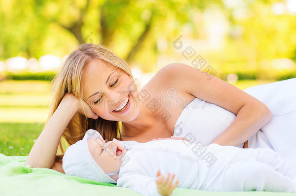 快乐的妈妈躺在毯子上，小宝宝躺在床上