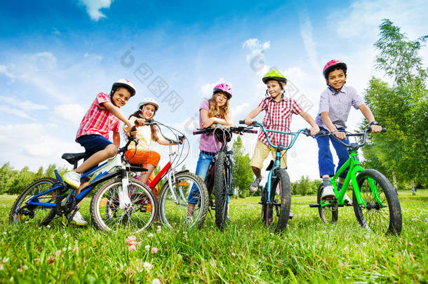 戴着彩色头盔的孩子们举着自行车
