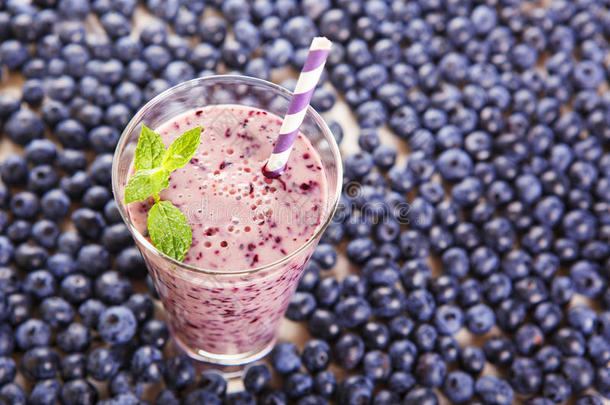 蓝莓冰沙放在一个玻璃罐里，里面放着一根稻草和一根薄荷枝