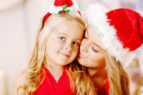 母亲和女儿打扮成圣诞老人庆祝圣诞节。家庭