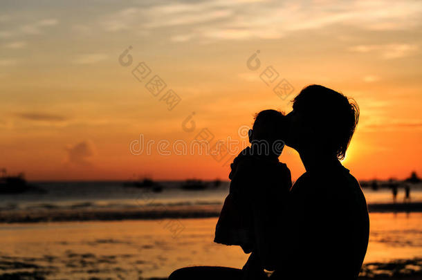 夕阳下，父亲和小女儿在海滩上