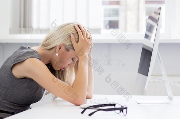 过度劳累和沮丧的年轻女子在电脑前