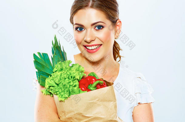 微笑的女人拿着<strong>绿色食品</strong>的袋子。