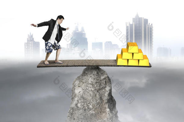 商人站在岩石跷跷板vs黄金堆上