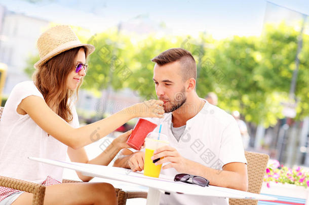 一对<strong>快乐</strong>的情侣在外面的咖啡馆喝冰沙