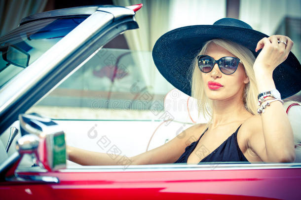 户外夏季画像时尚金发<strong>复古</strong>女人驾驶敞篷红色<strong>复古</strong>车。时尚迷人的金发女孩