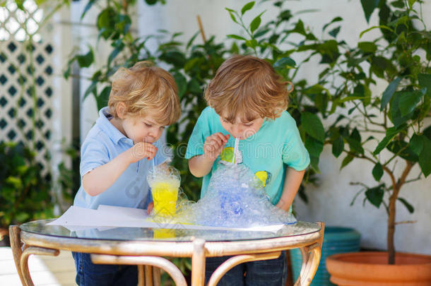 两个快乐的兄弟姐妹用彩色泡泡做实验