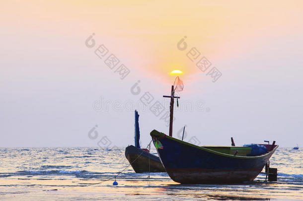 泰国渔船在海滩上与美丽的昏暗天空相映