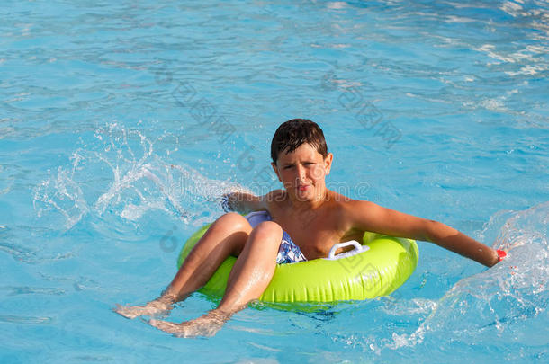 男孩游泳衣在游泳池里漂浮