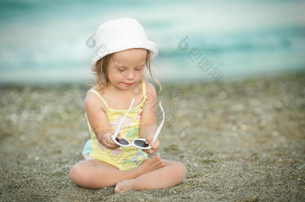 唐氏综合症小女孩在沙滩上玩太阳眼镜