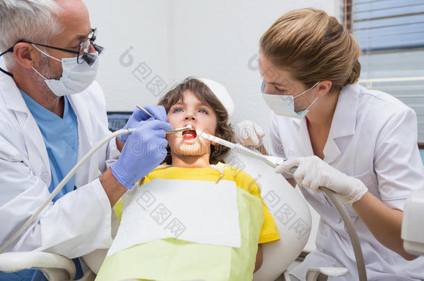 儿科牙医在牙医椅上检查一个小男孩的牙齿