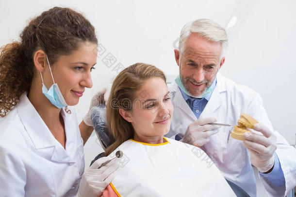 牙医和助手在牙医椅子上检查病人的牙齿