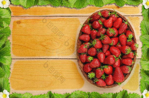 <strong>草莓</strong>放在木桌上的篮子里，有<strong>草莓叶子</strong>和花的框架-鸟瞰图