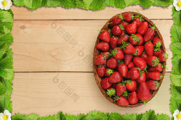 草莓放在木桌上，篮子里放着草莓叶子