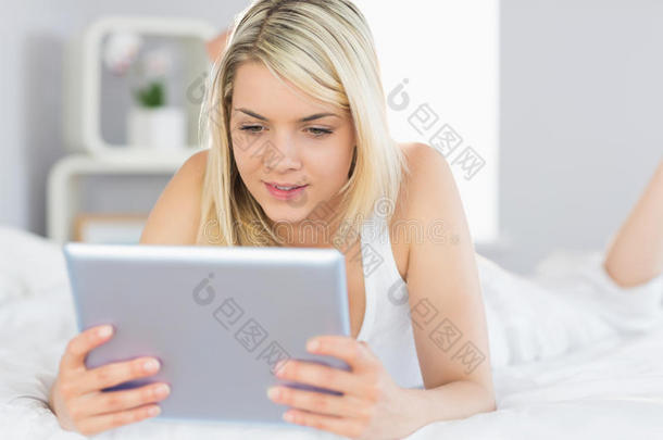 放松美女床上用数码平板电脑