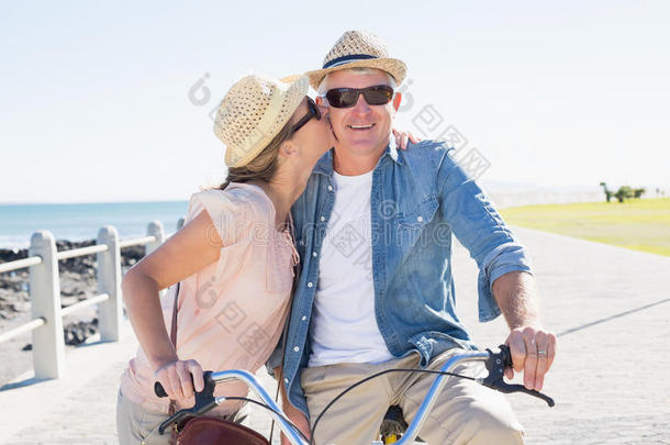 快乐的休闲情侣去码头骑自行车