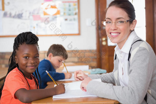 可爱的小学生在教室里得到老师的帮助