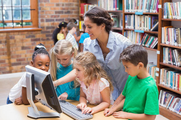 可爱的学生和老师在<strong>图书馆</strong>看电脑