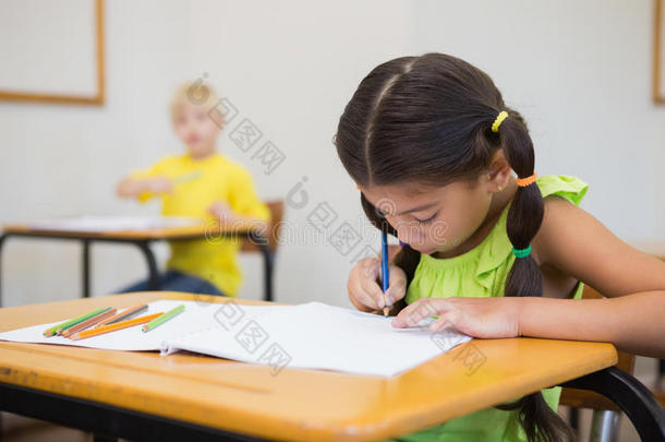 可爱的小学生在教室的<strong>课桌</strong>前涂色