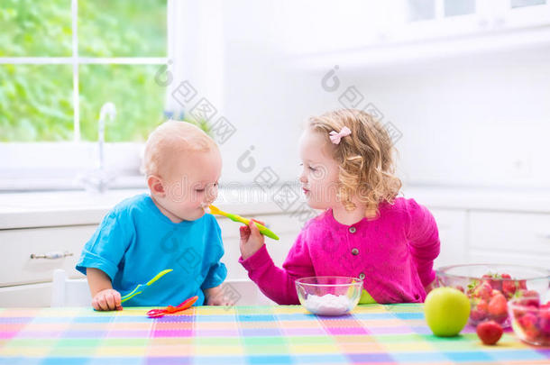 两个孩子在吃酸奶