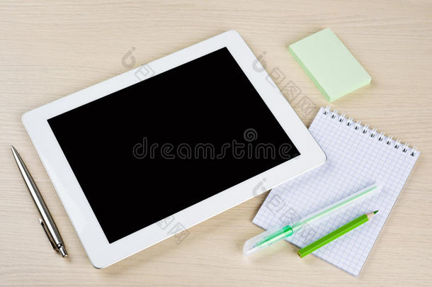 桌面上有笔记、笔和悬挂物的平板电脑