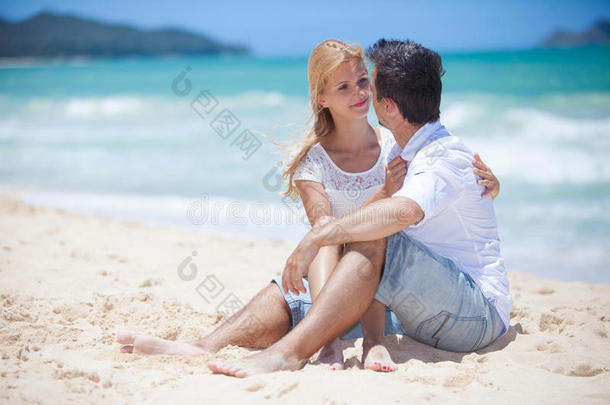 一对欢快的情侣在沙滩上<strong>拥抱</strong>并摆<strong>姿势</strong>