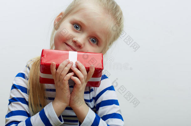 女孩拿着白色<strong>丝带</strong>的红色<strong>礼盒</strong>。