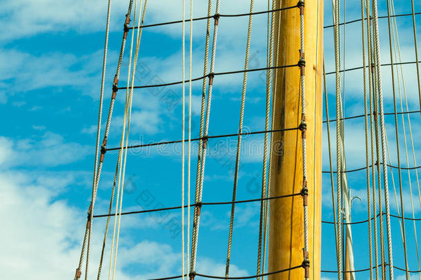 游艇桅顶着夏日蔚蓝的天空。游艇