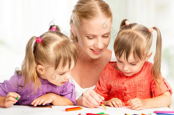 一对双胞胎姐妹在幼儿园和妈妈一起画画